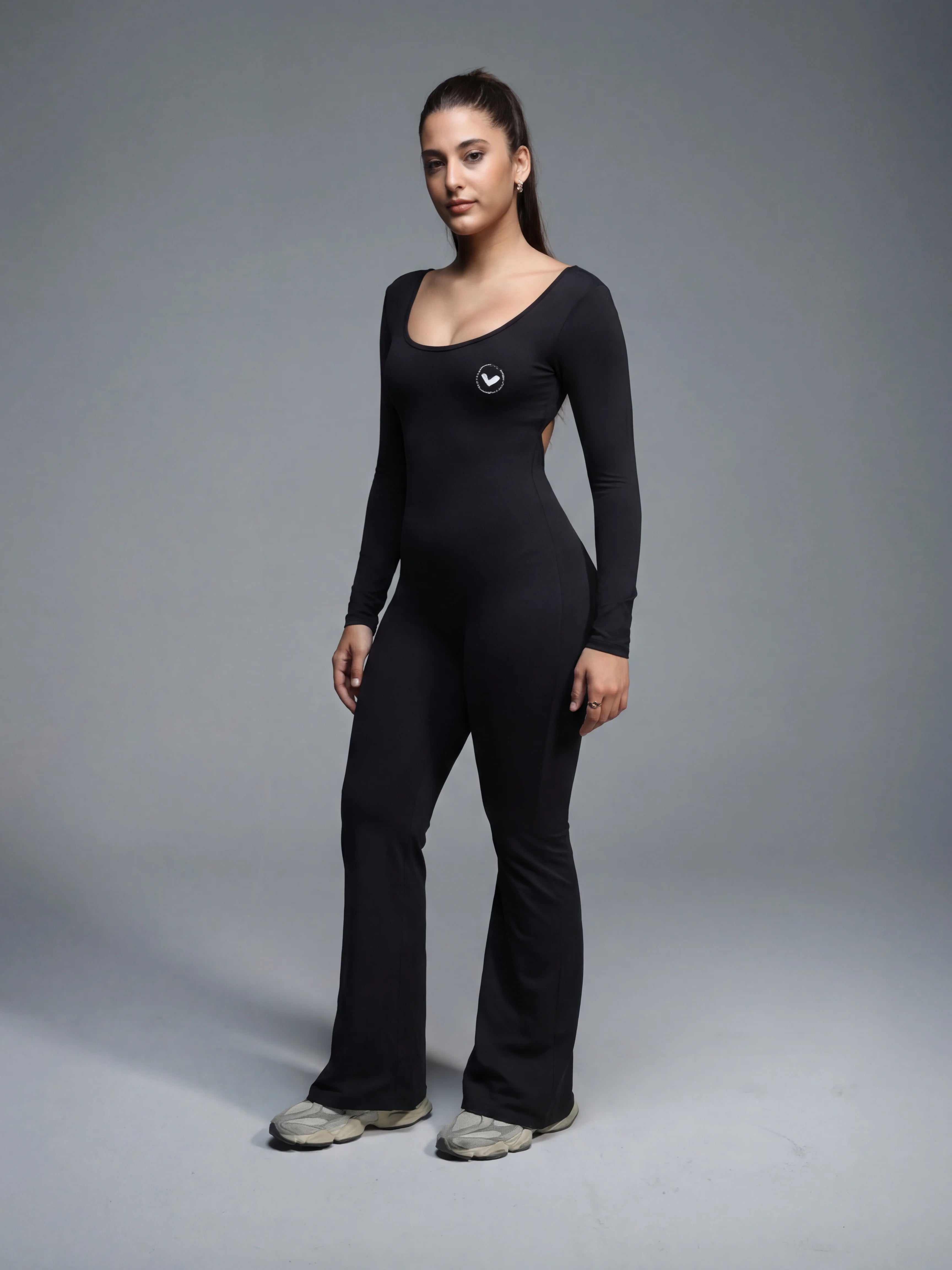 Woman wearing a black bodysuit against a gray background