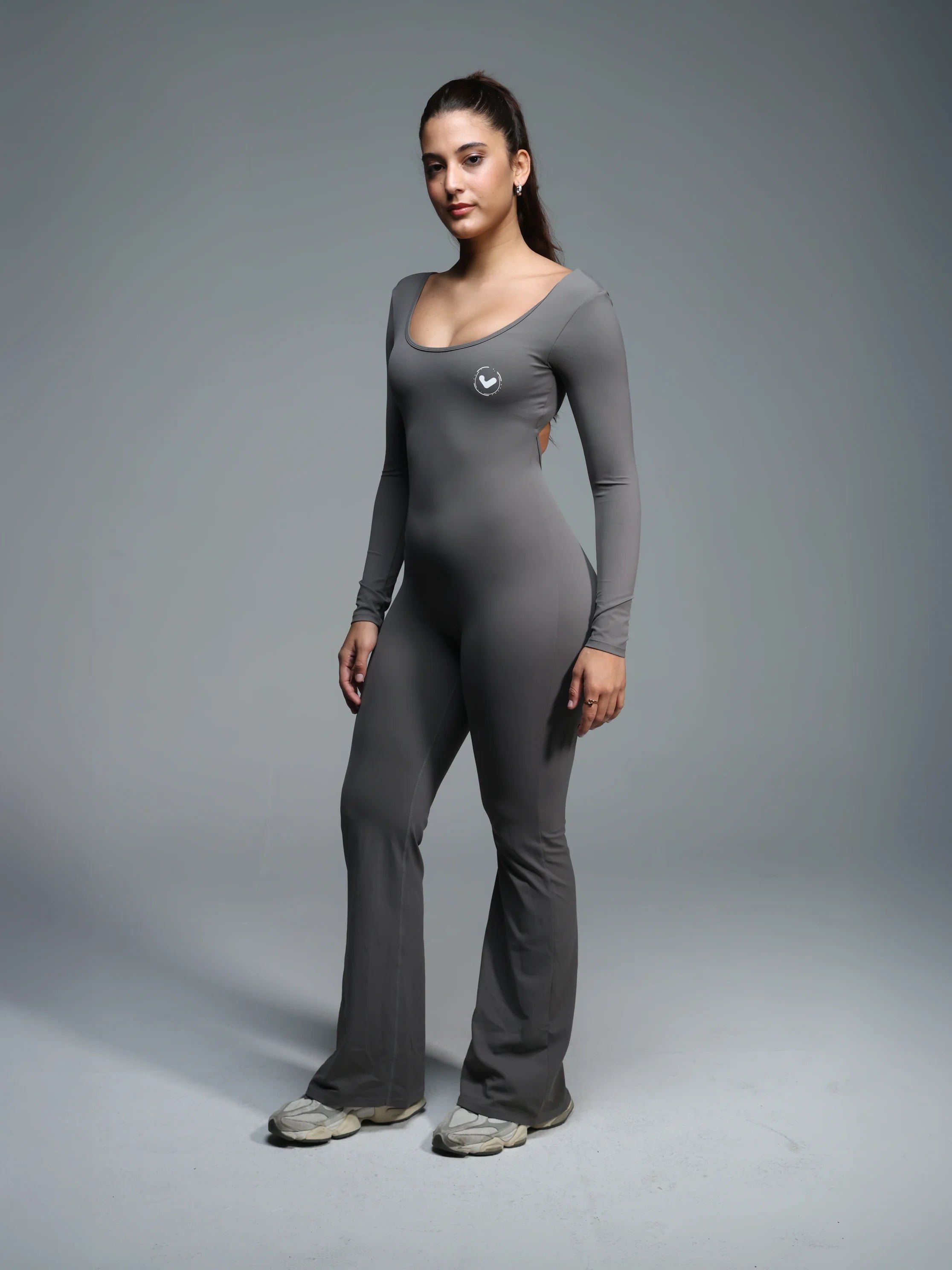 Woman wearing a gray bodysuit on a gray background