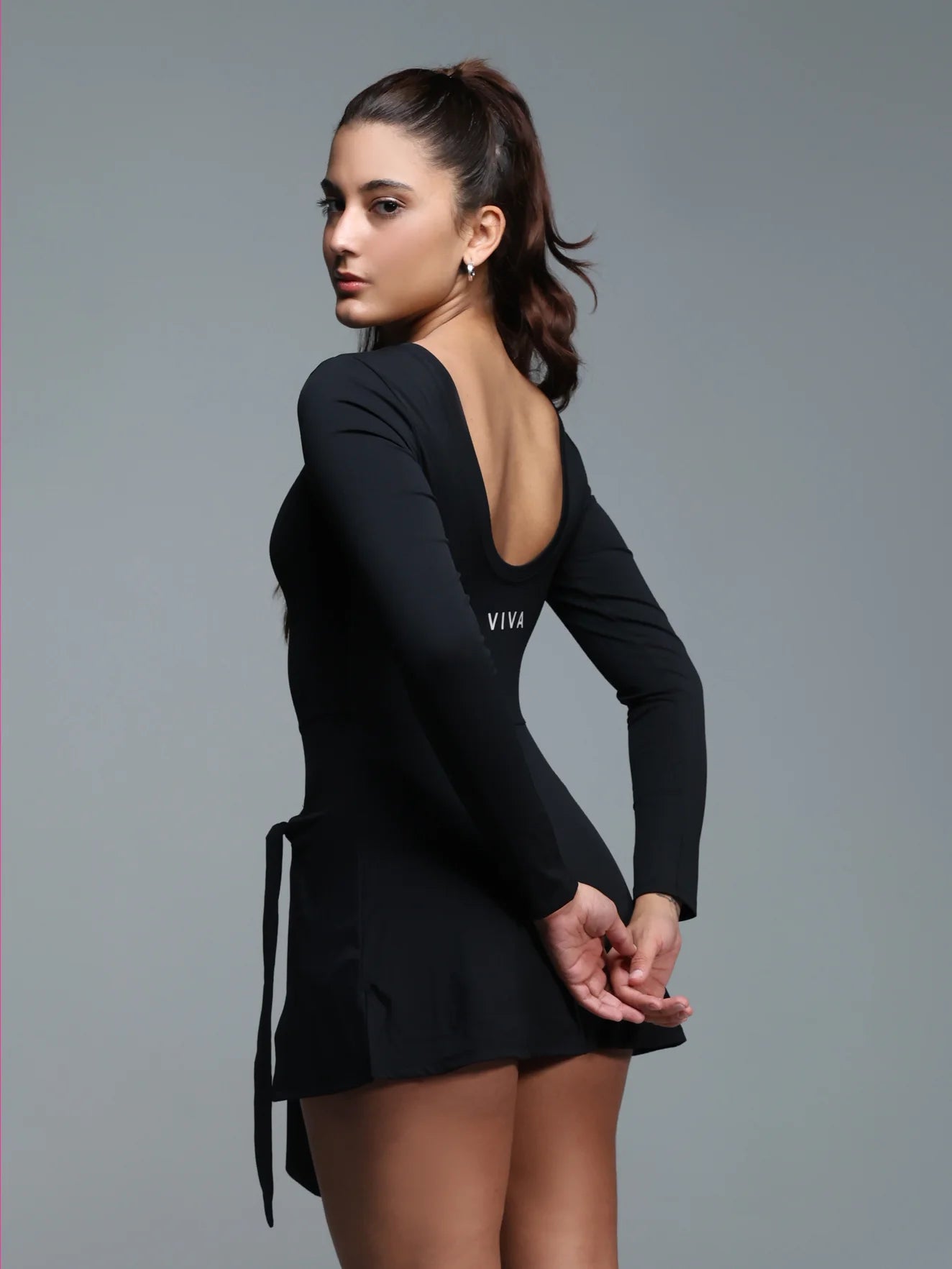 Woman wearing a black dress with 'VIVA' branding on a gray background