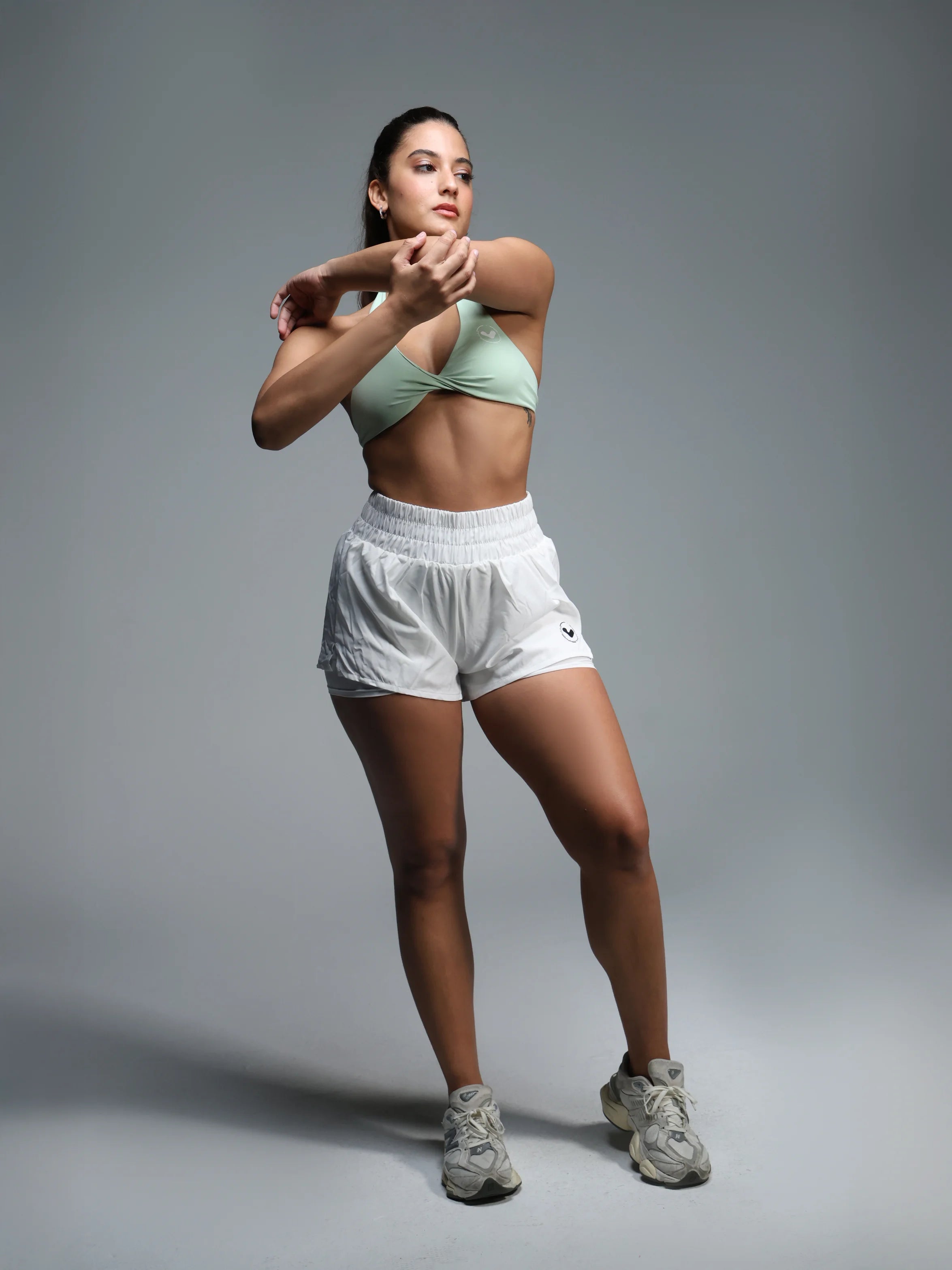 Woman in athletic wear posing against a gray background