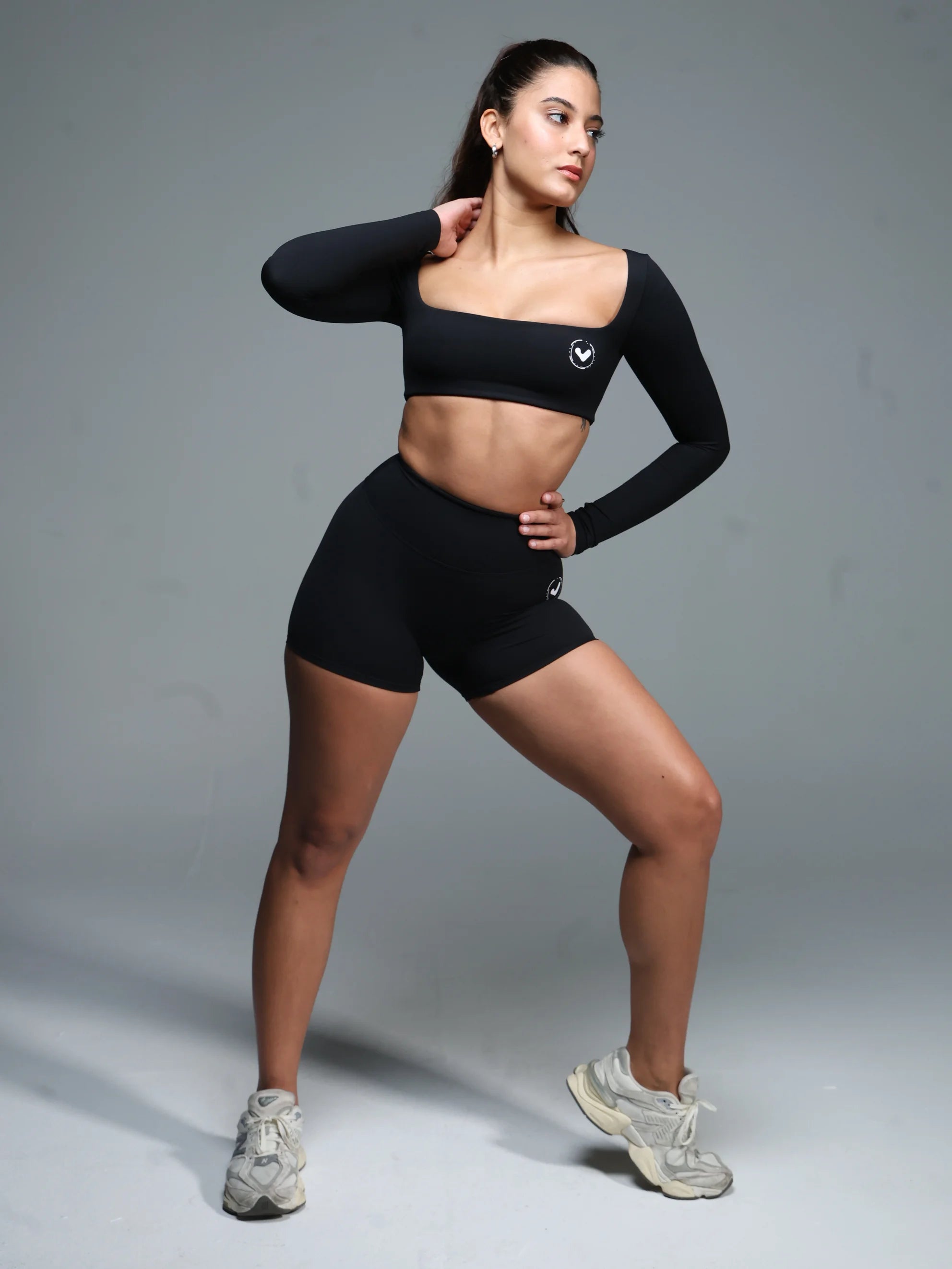 Woman wearing a black athletic outfit on a gray background