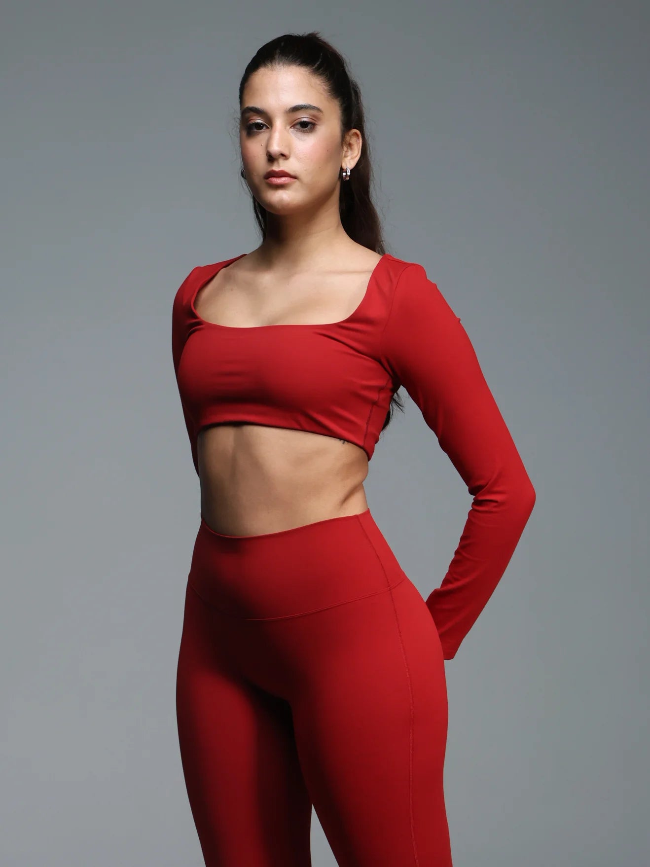 Woman wearing a red athletic outfit on a gray background