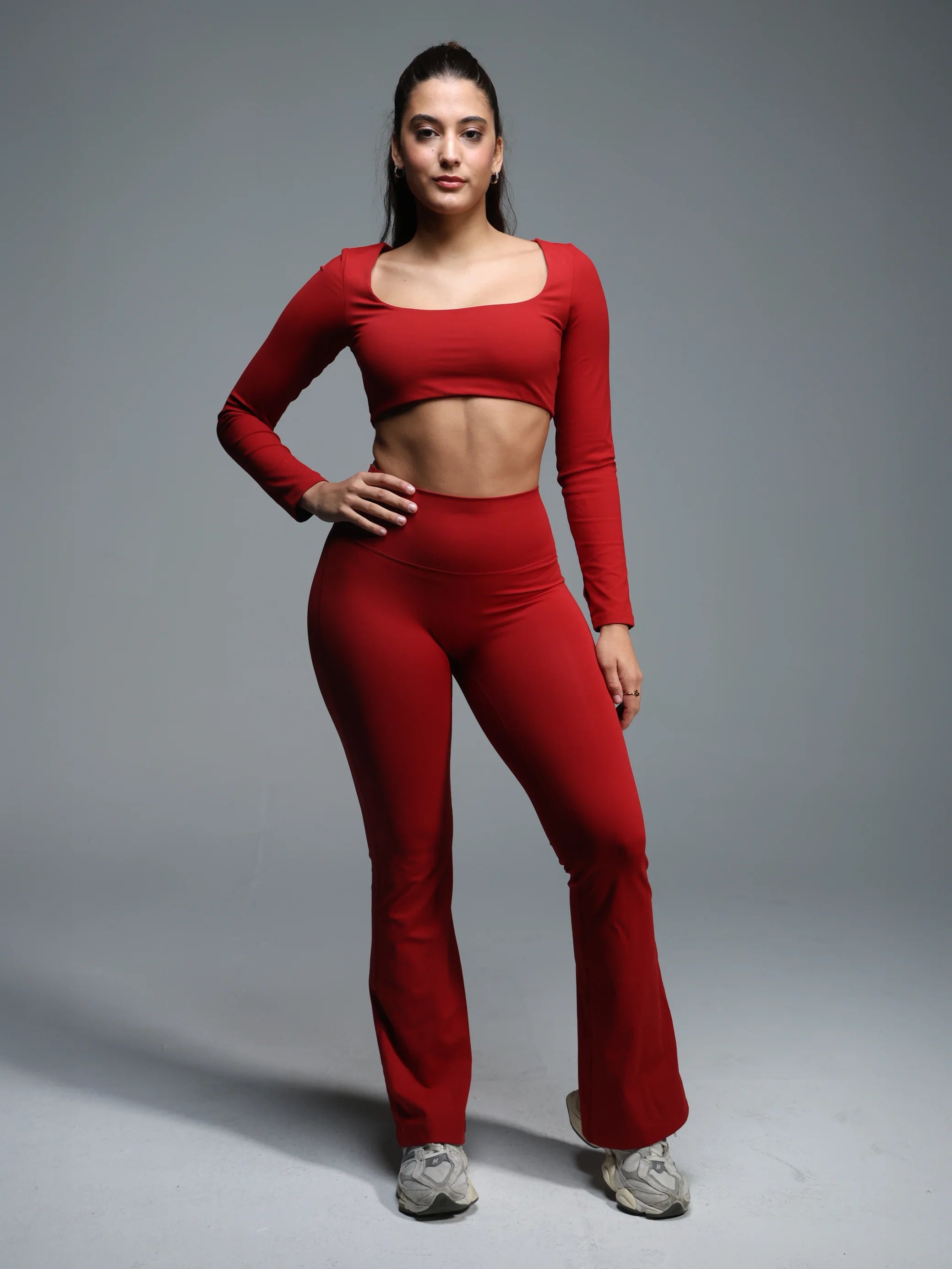 Woman wearing a red athletic outfit on a gray background